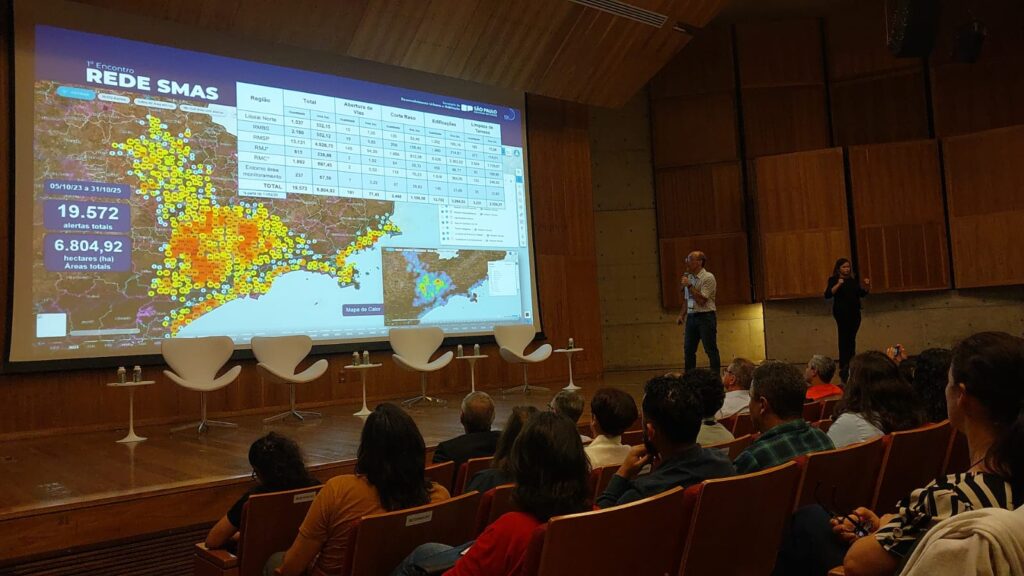 Imagem mostra equipe analisando dados e mapas do Sistema de Monitoramento de Alertas por Satélite utilizado para identificar riscos ambientais em 79 municípios de São Paulo.