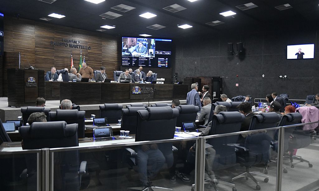 Plenário da Câmara de Guarulhos durante sessão, com transmissão disponível ao público.