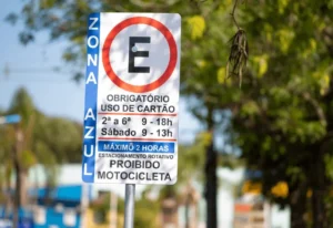 Placa de sinalização da Zona Azul em rua movimentada de São Paulo indicando o novo valor da tarifa
