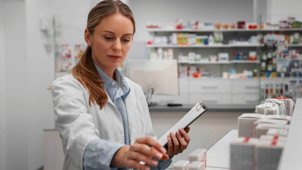 Profissional da área farmacêutica organizando medicamentos em farmácia