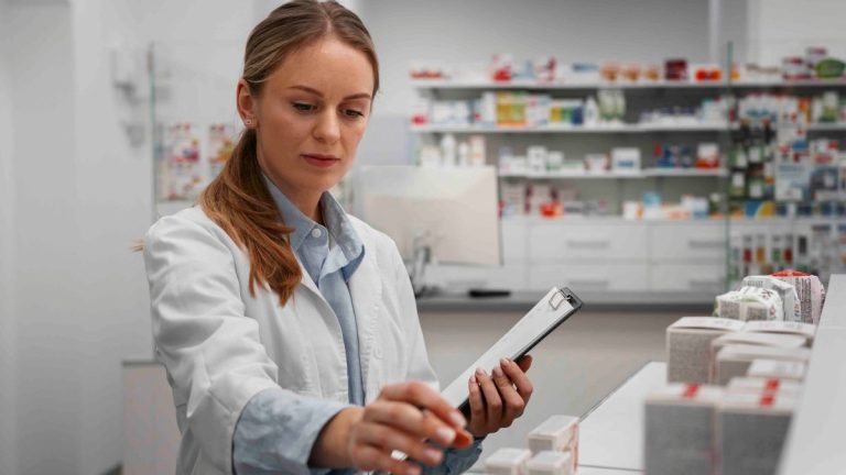 Profissional da área farmacêutica organizando medicamentos em farmácia