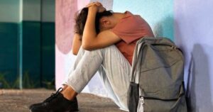Adolescente sozinho durante as férias escolares, período que pode aumentar a sensação de isolamento e exigir atenção dos pais