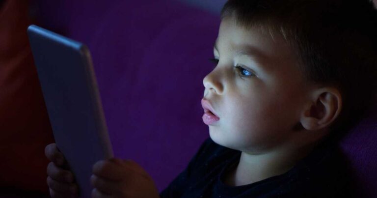 Criança utilizando dispositivo eletrônico, hábito que pode provocar olhos cansados e outros desconfortos quando há excesso de tempo diante das telas