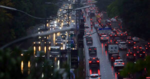 Trânsito de veículos em São Paulo durante chuva intensa, condição que pode reduzir a velocidade média em até 14,8%