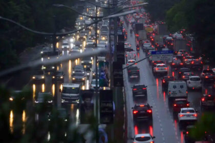 Trânsito de veículos em São Paulo durante chuva intensa, condição que pode reduzir a velocidade média em até 14,8%