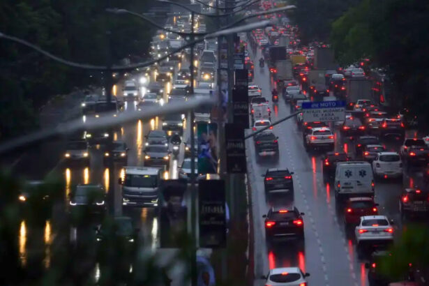 Trânsito de veículos em São Paulo durante chuva intensa, condição que pode reduzir a velocidade média em até 14,8%